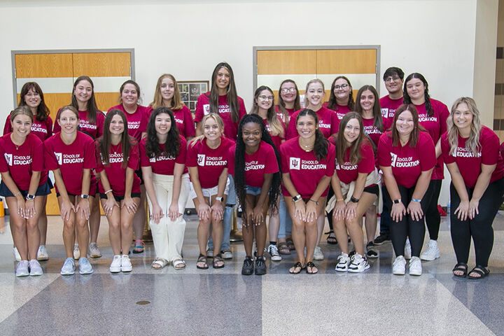 A group of students wearing School Of Education shirts, pose for a picture.